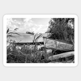 Old canoes and kayaks on the river bank in Thurne, Norfolk Sticker